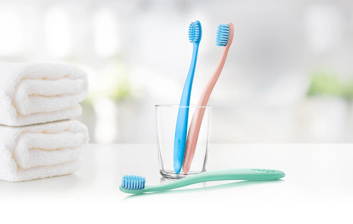 TRISA Eco toothbrushes made from sustainable materials standing in a glass.