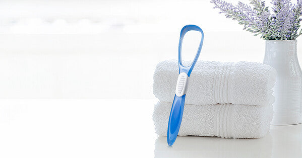 TRISA tongue cleaner shown in a clean setting.